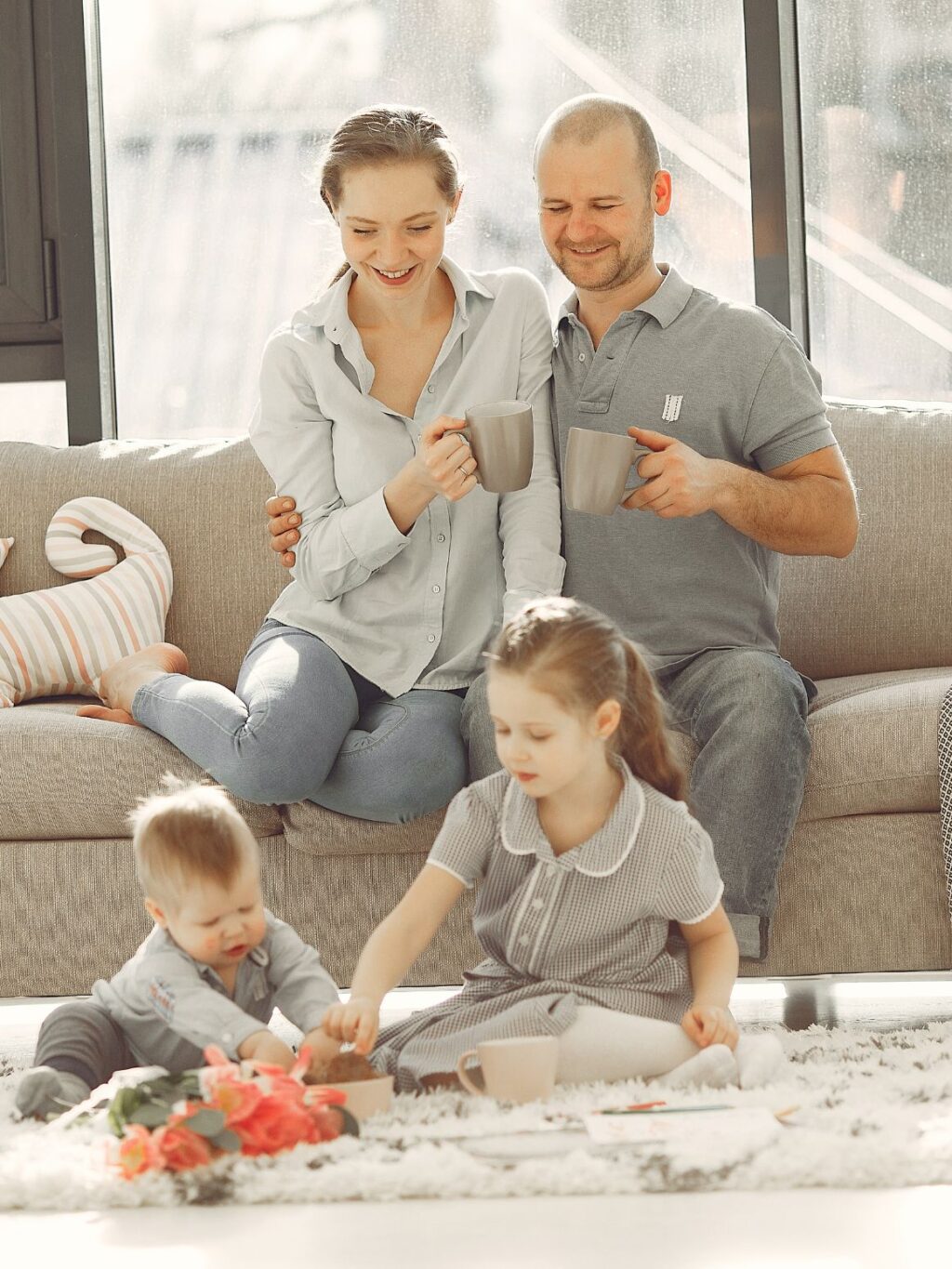 Family sitting in living room with children on the floor, with their house organized from Orderly Nest Organizing Services in Salt Lake City